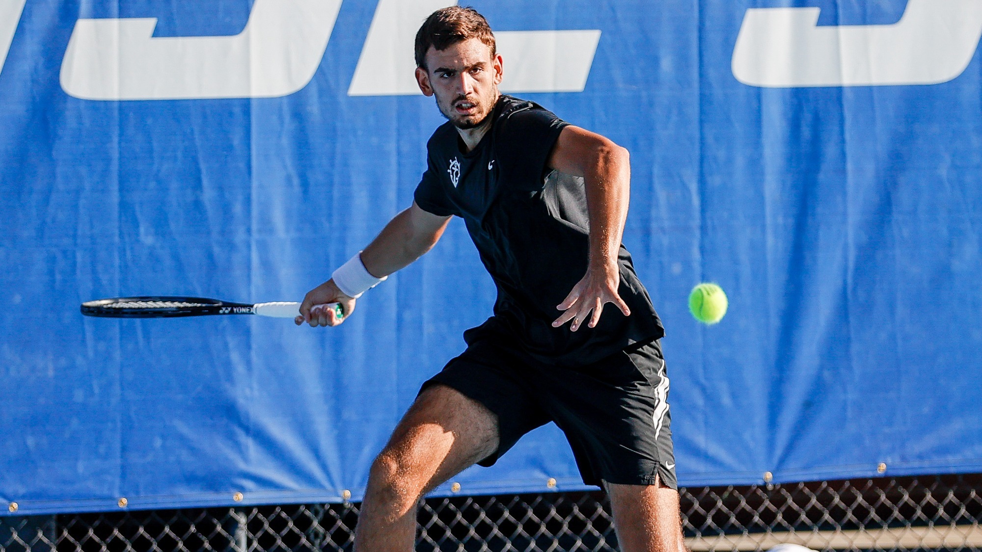 Stefan Skobelev hits a forehand during a road match.