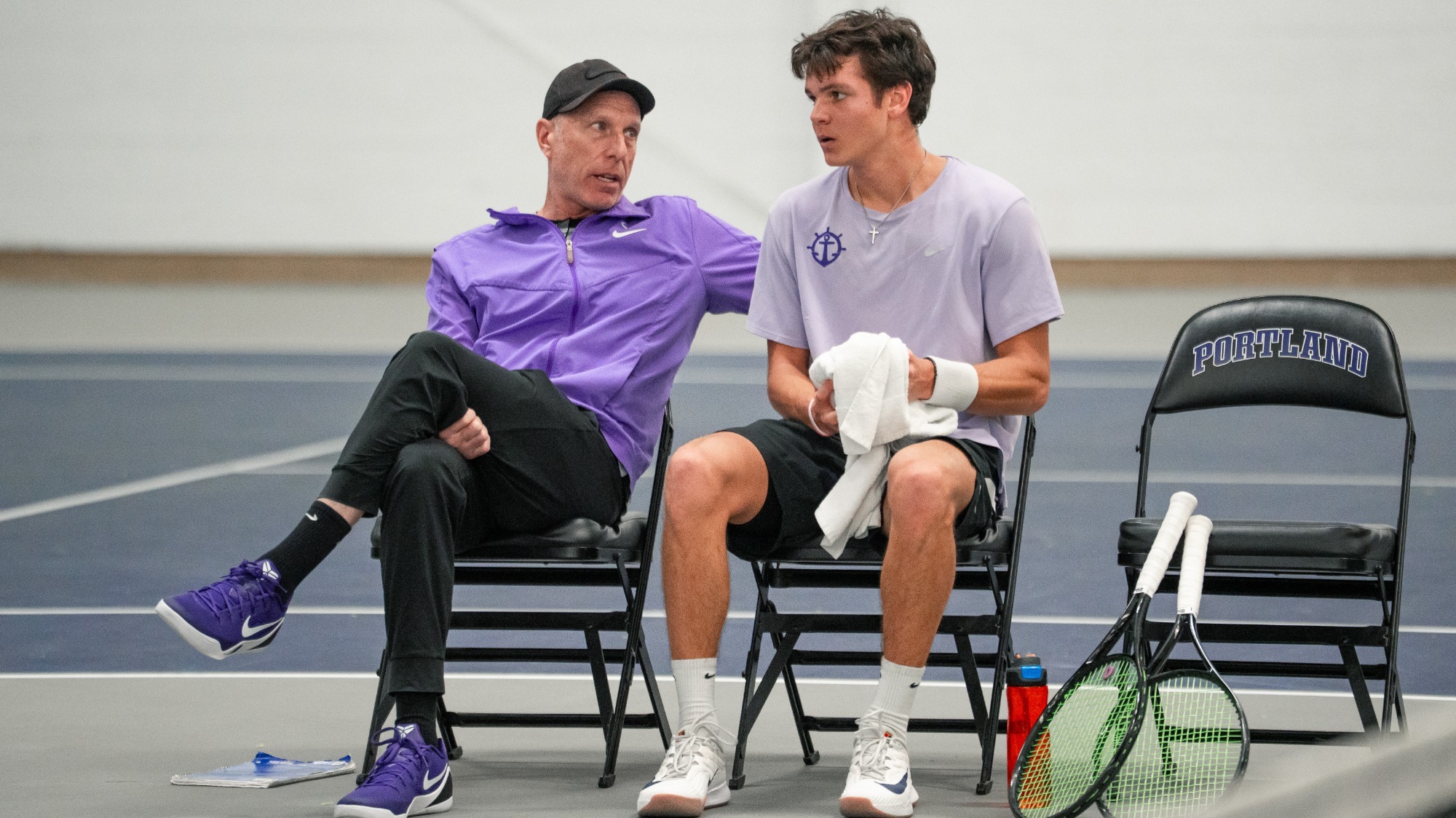 Aaron Gross and Cade Fernando sitting during a singles match at a crossover.