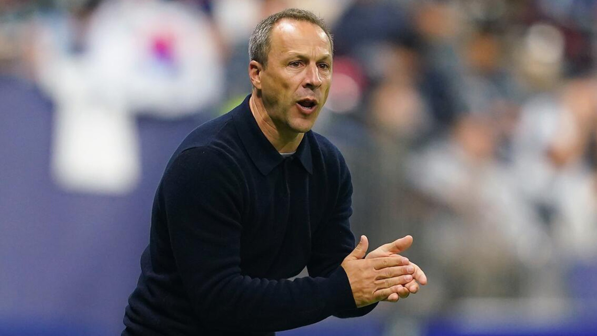 Steve Cherundola claps while coaching from the sidelines for LAFC.