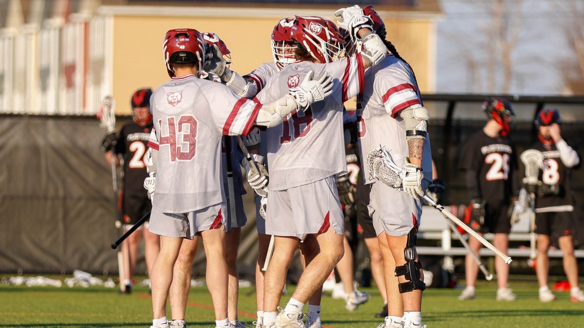 Men's Lacrosse players celebrate in a group against Plattsburgh on 04/08/26. 