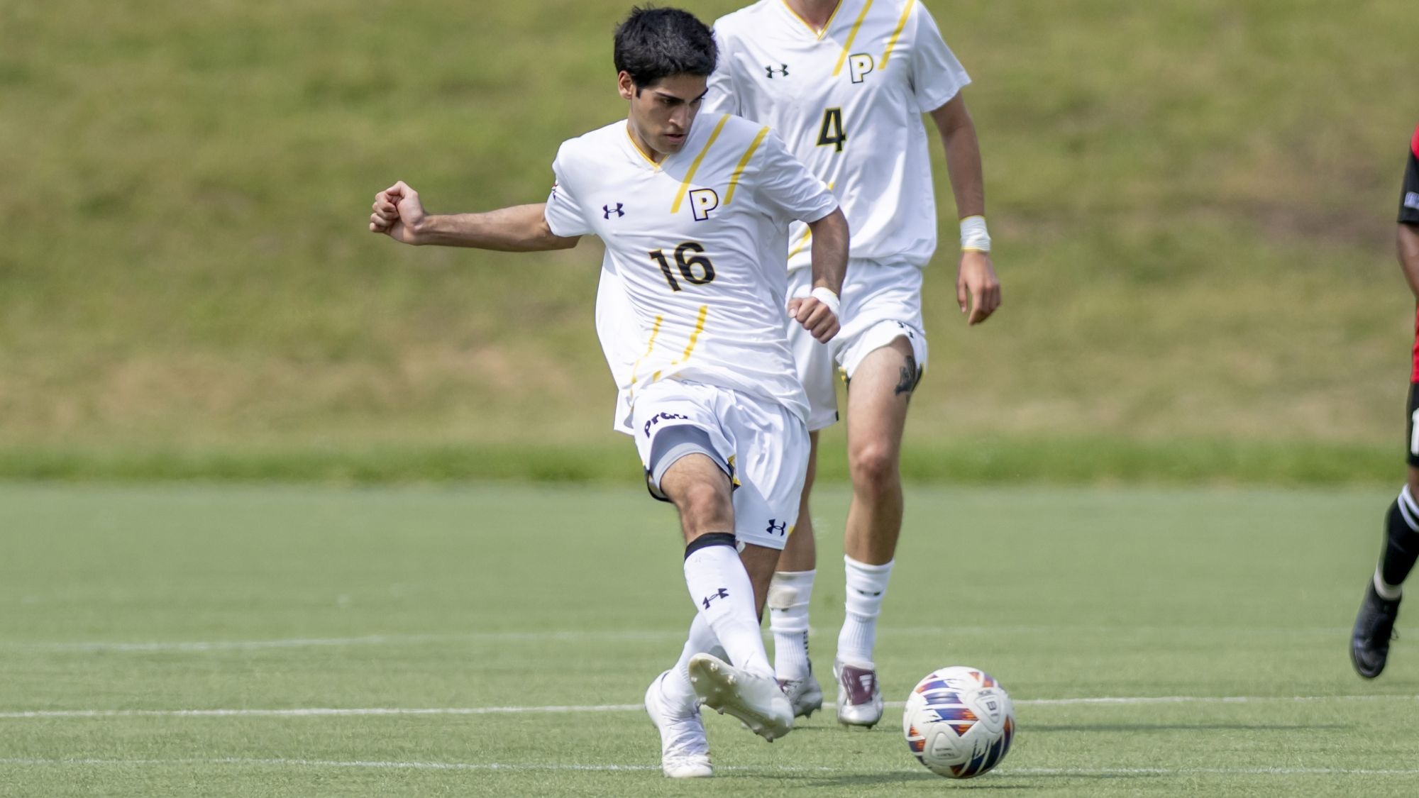 Aditya Shivkumar kicks the ball with his right foot.