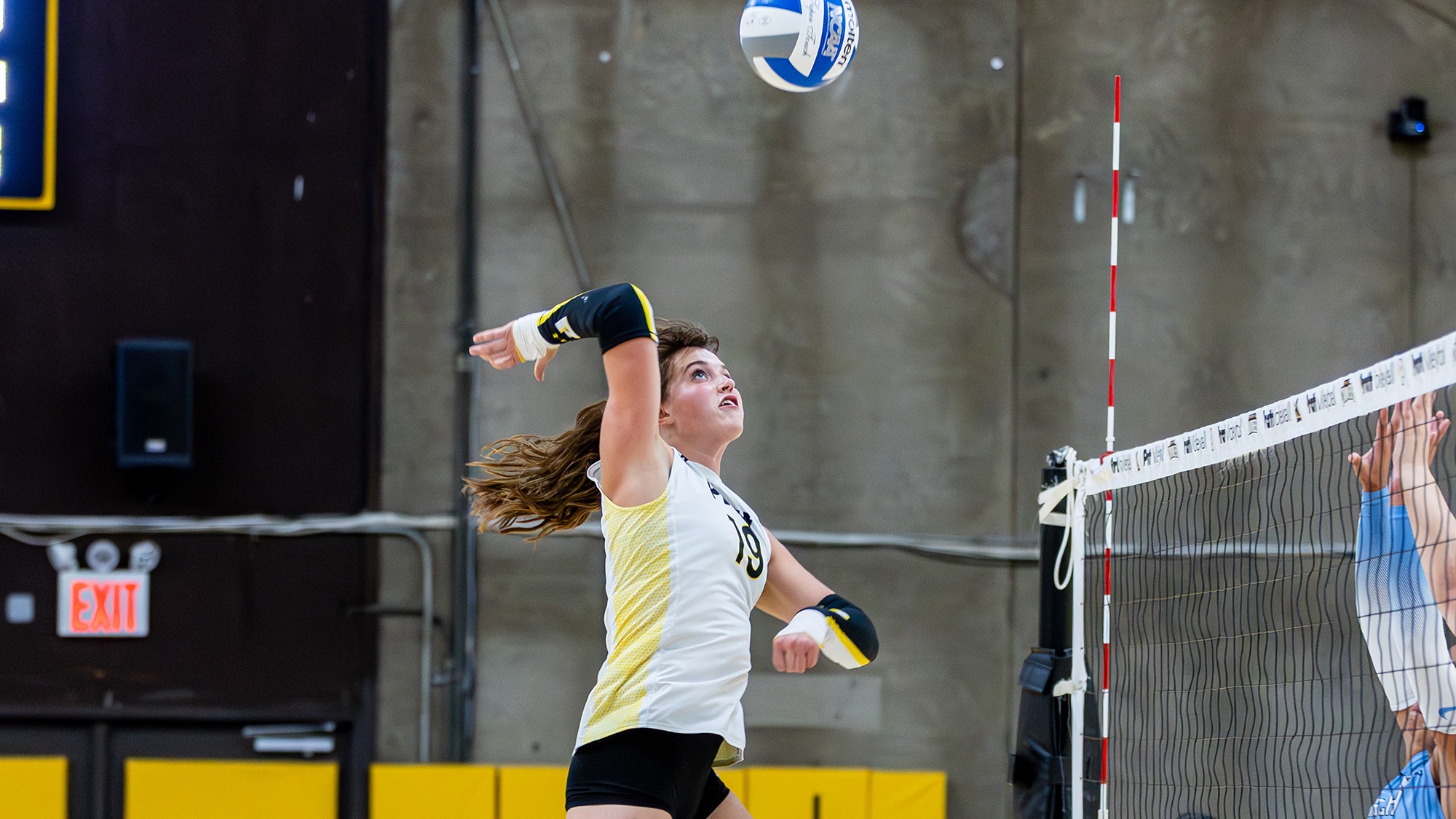 Colleen Russell rises to spike a ball in the middle.