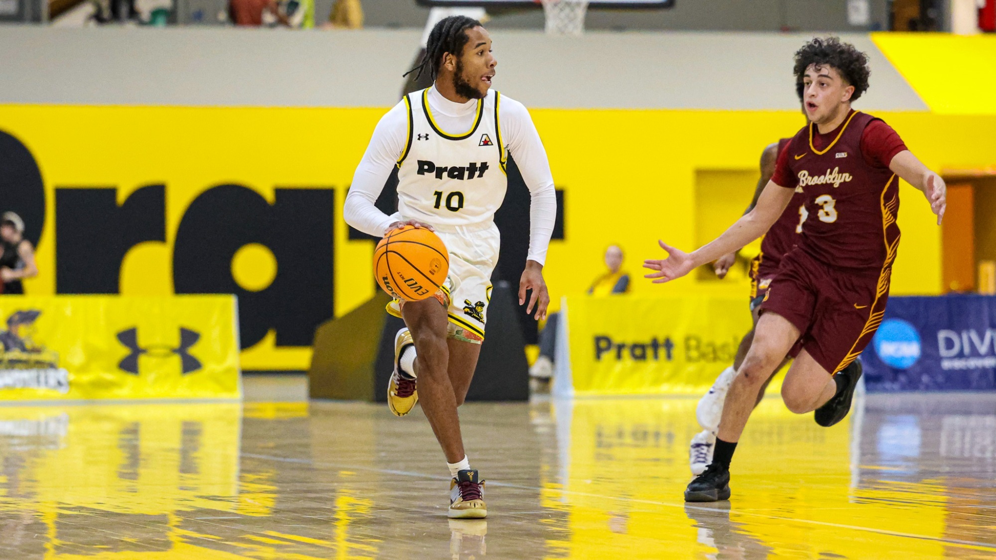 Mekhi Davis dribbles at mid-court with a Brooklyn defender following.