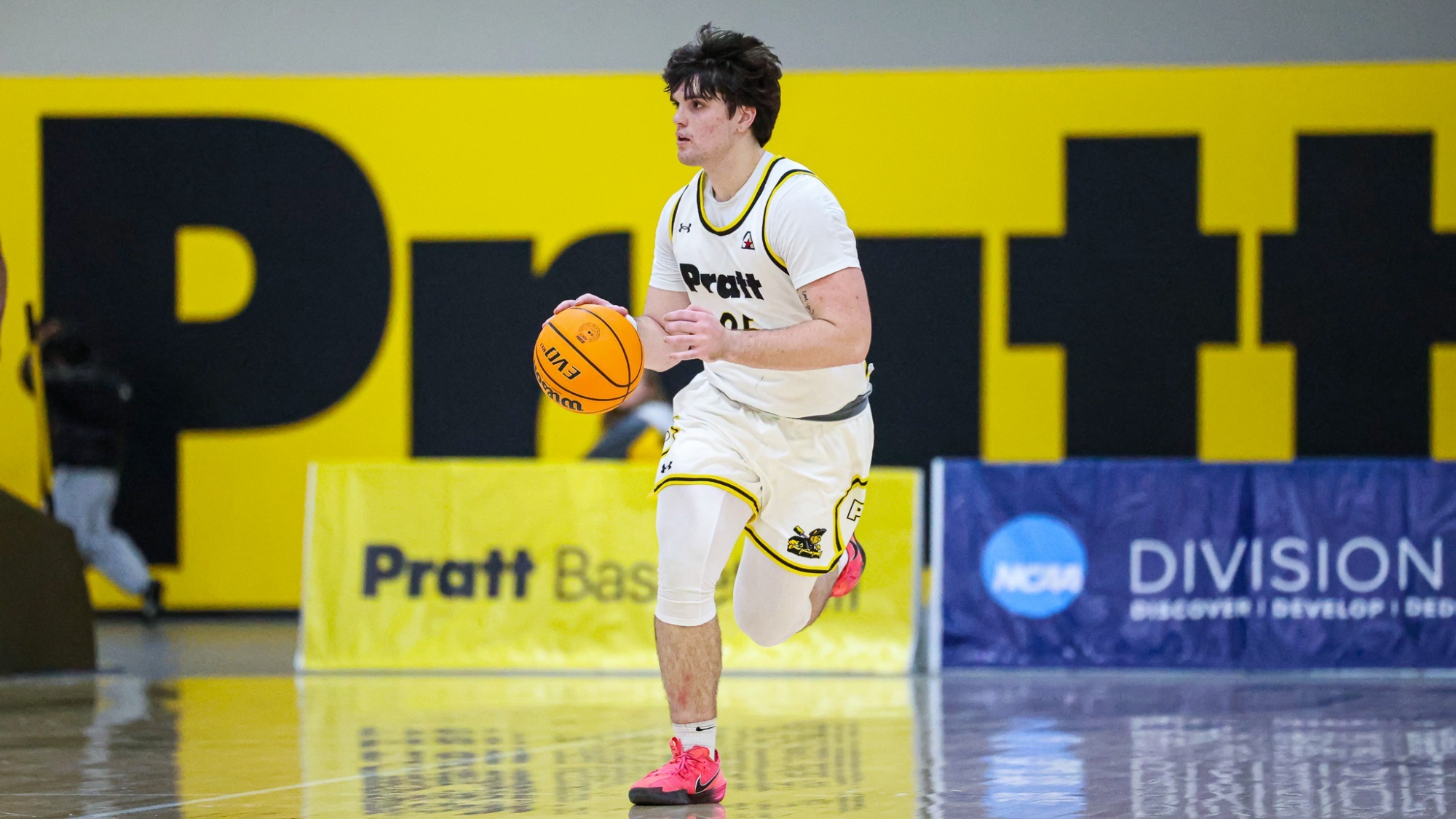 Mason Fritz dribbles at mid-court with his right hand.