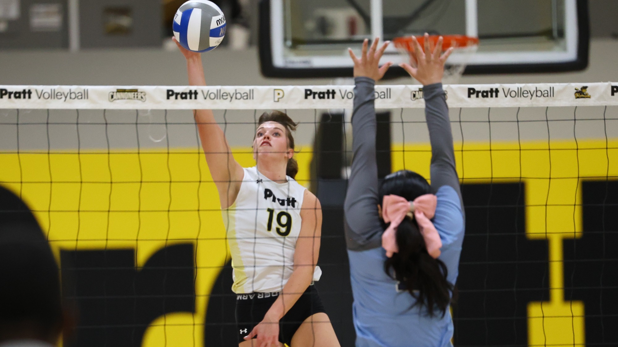 Colleen Russell spikes a ball with a St. Elizabeth defender at the net.