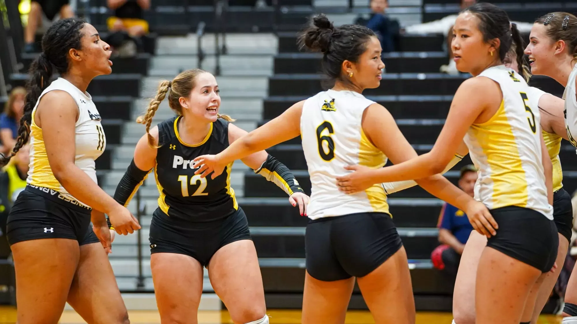 The women's volleyball team celebrates after winning a point.