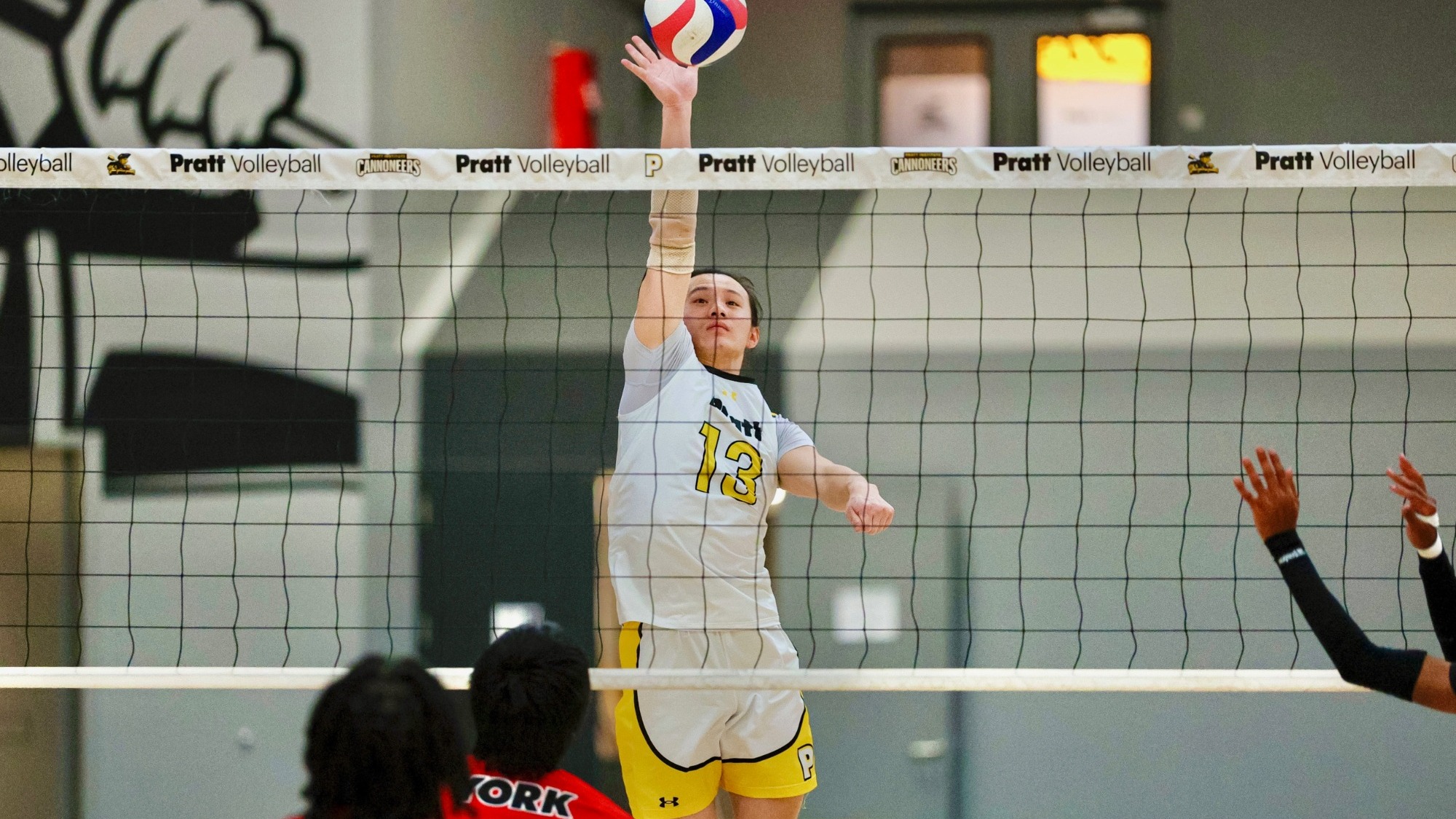 Max Wang attempts a spike at the net with his right hand.