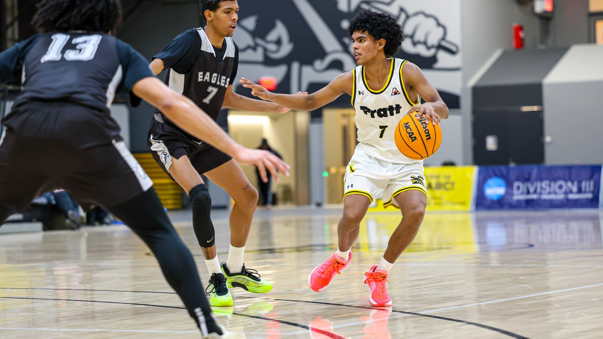 Elijah Fermaint dribbles away from 2 defenders.