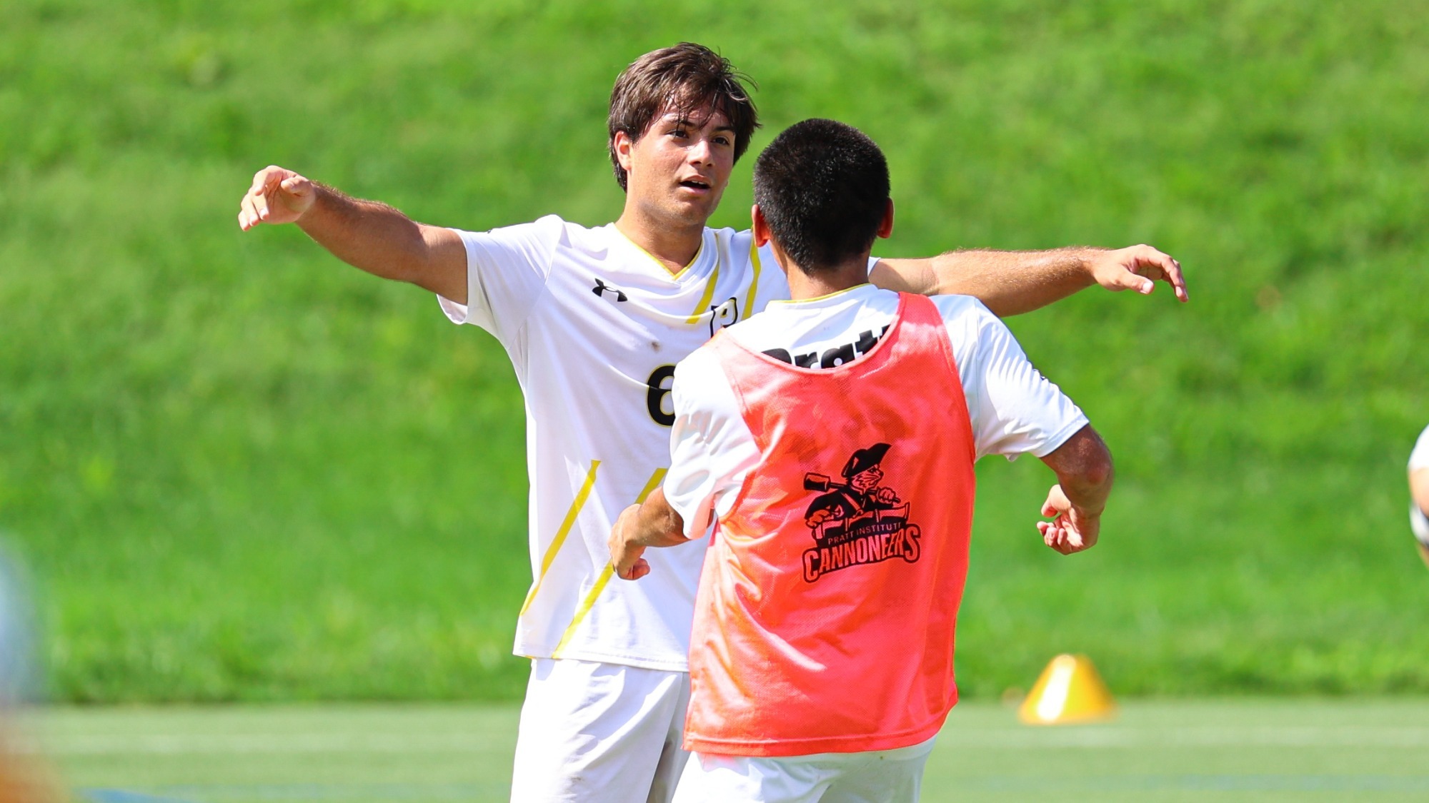 Lucca Novi with his arms out in celebration preparing to embrace a teammate after Pratt's victory over SUNY Cobleskill