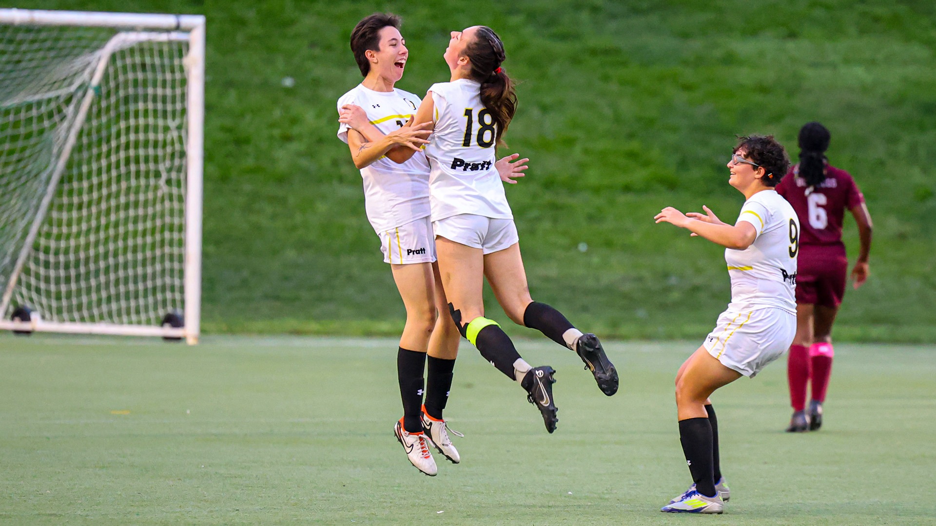Emma Pratt and Kate Nolan bump in the air in celebration after Emma Pratt scored a goal.