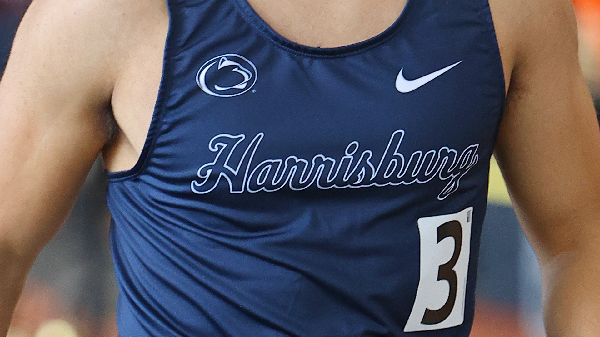 close up of a men's track & field athlete's uniform with the penn state logo and harrisburg script across the front