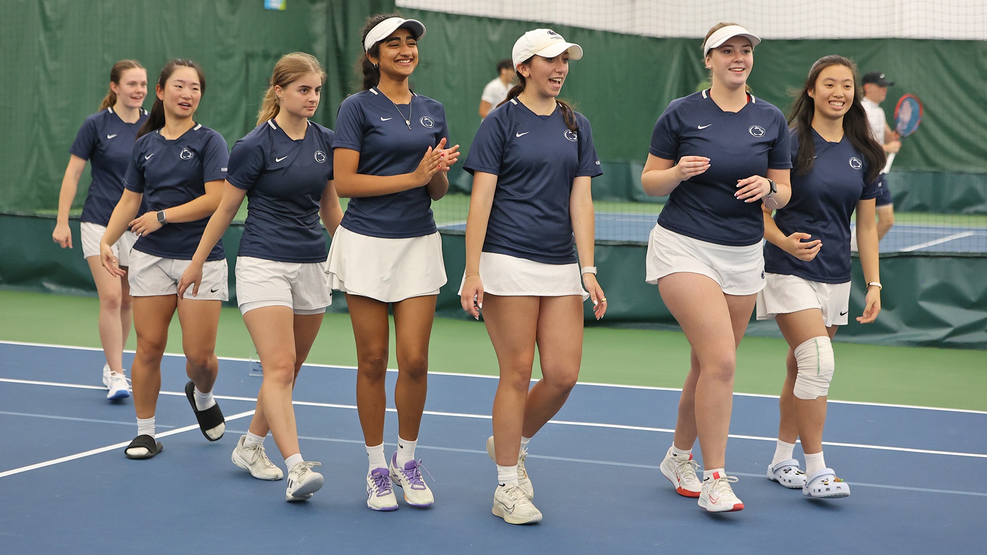 women's tennis team smiles before collecting the united east championship trophy in 2025