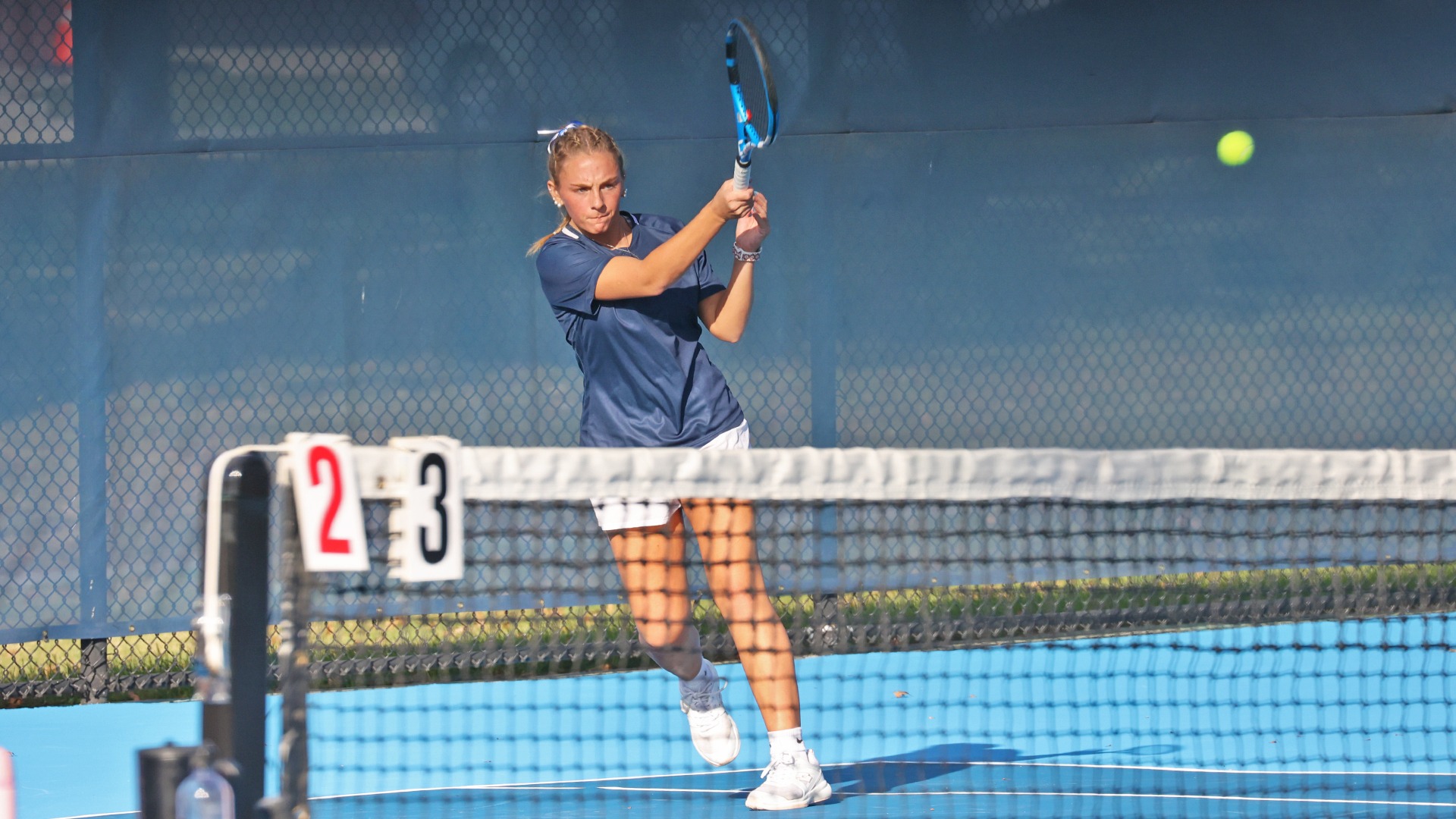 Kiersten Strohecker hits a ball over the net at the hoverter tennis complex