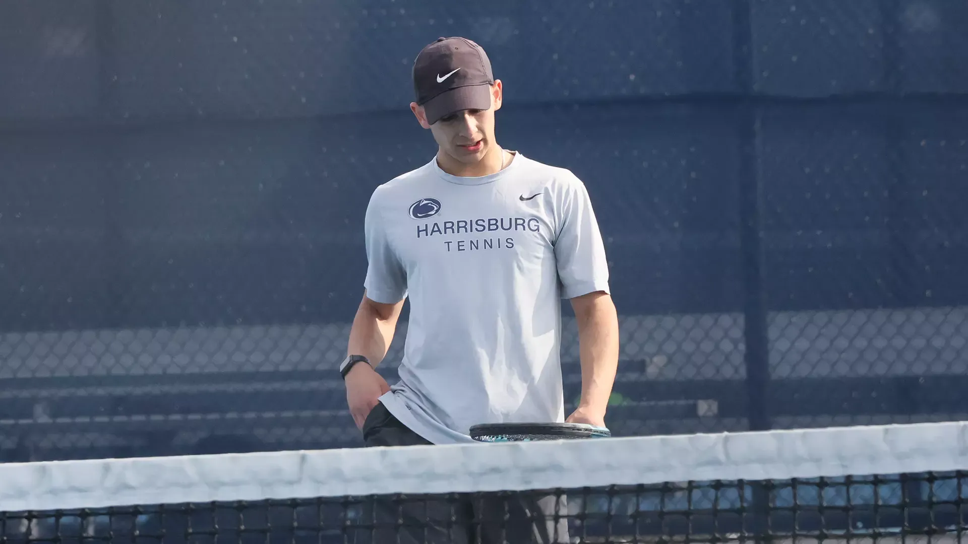 ian opitz looks down at his racket