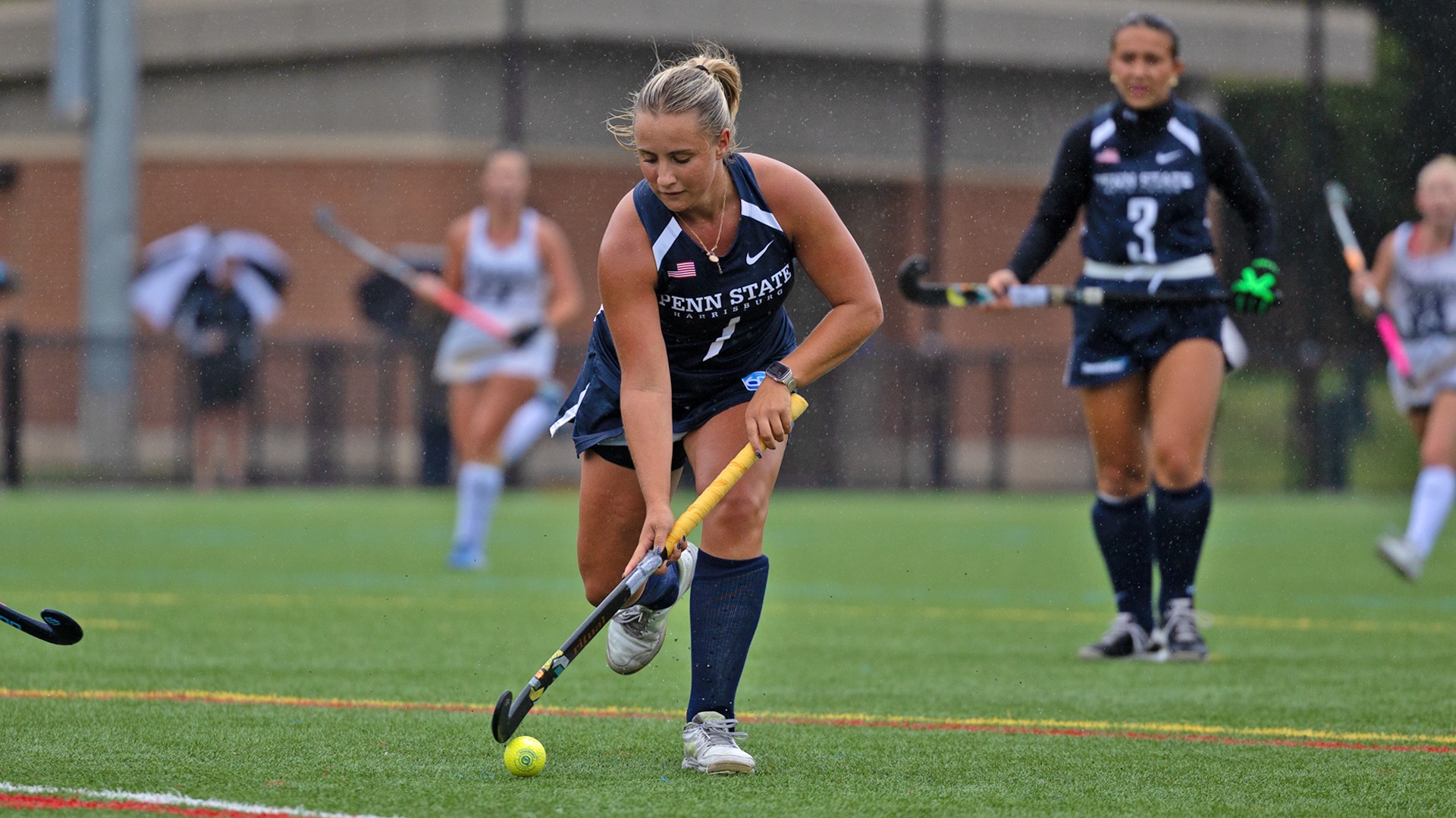 astrid comp dribbles the ball down the field in the rain against neumann