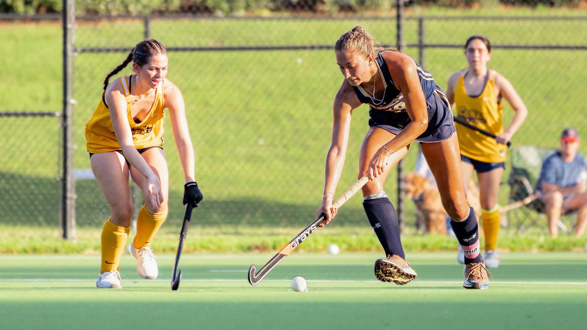Maddie Just dribbling with field hockey stick.