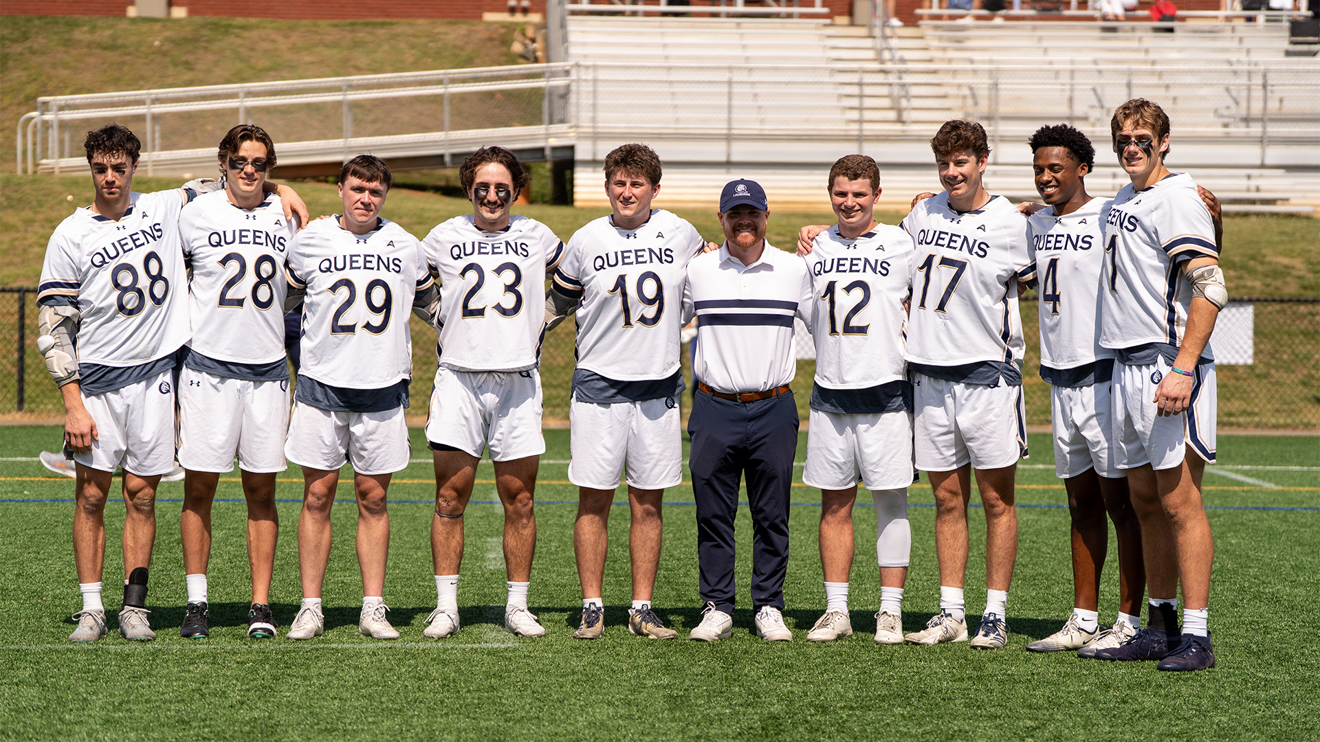 2026 Queens men's lacrosse seniors with Queens Head Coach Nik Colpitts during Senior Day celebration. 