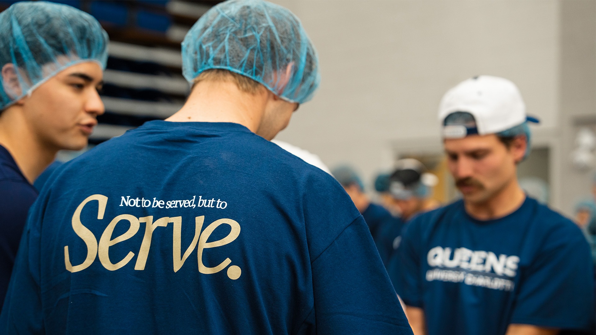 Queens University of Charlotte student-athletes at the Day of Service inside Curry Arena packing meals