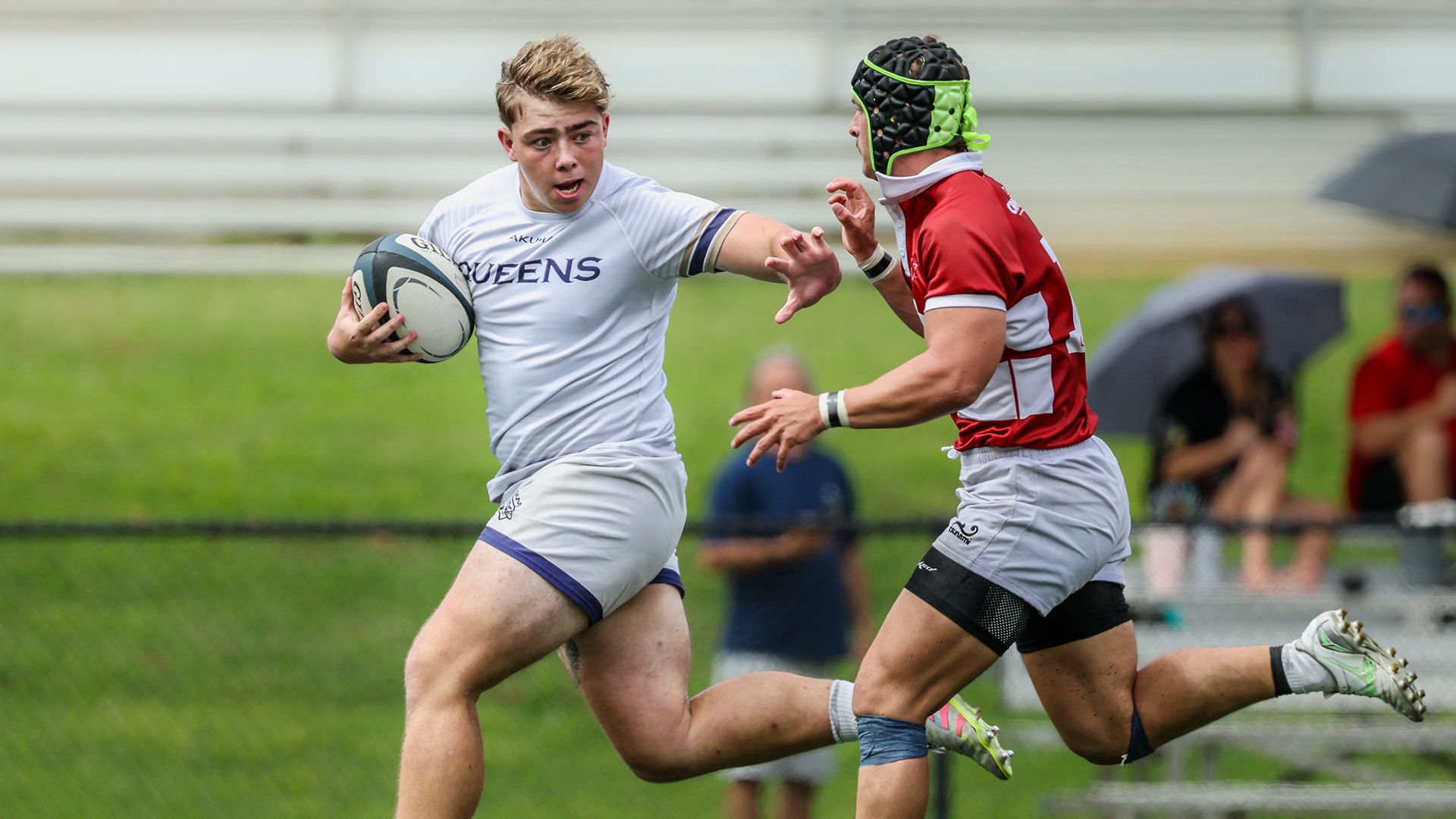 Rugby player stiff arming the defense 