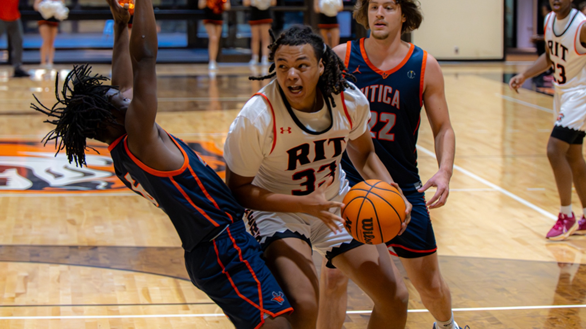 A men's basketball player from Rochester Institute of Technology drives to the hoop against a defender