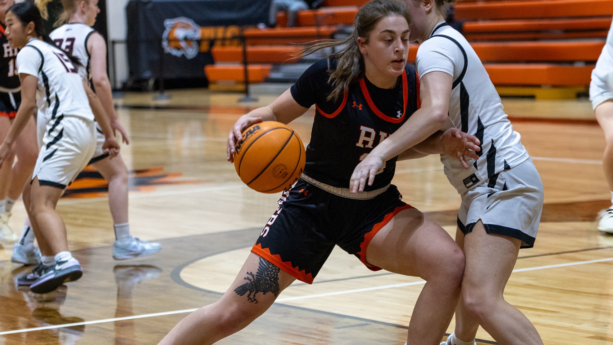 a women's basketball player for Rochester Institute of Technology drive the lane in a game for the Tigers