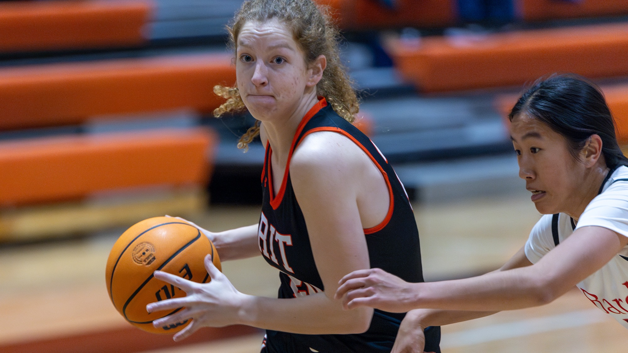 A women's basketball player for Rochester Institute of Technology drives to the basket