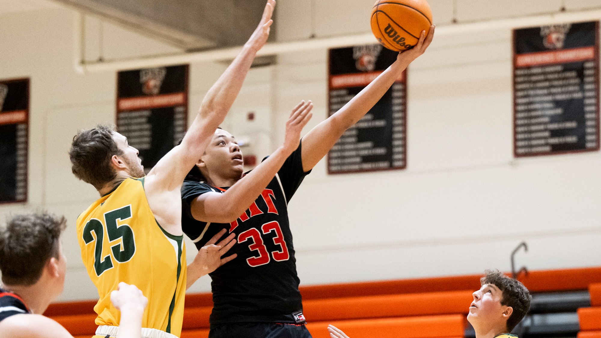a men's basketball player drives the lane to make a lay-up for Rochester Institute of Technology
