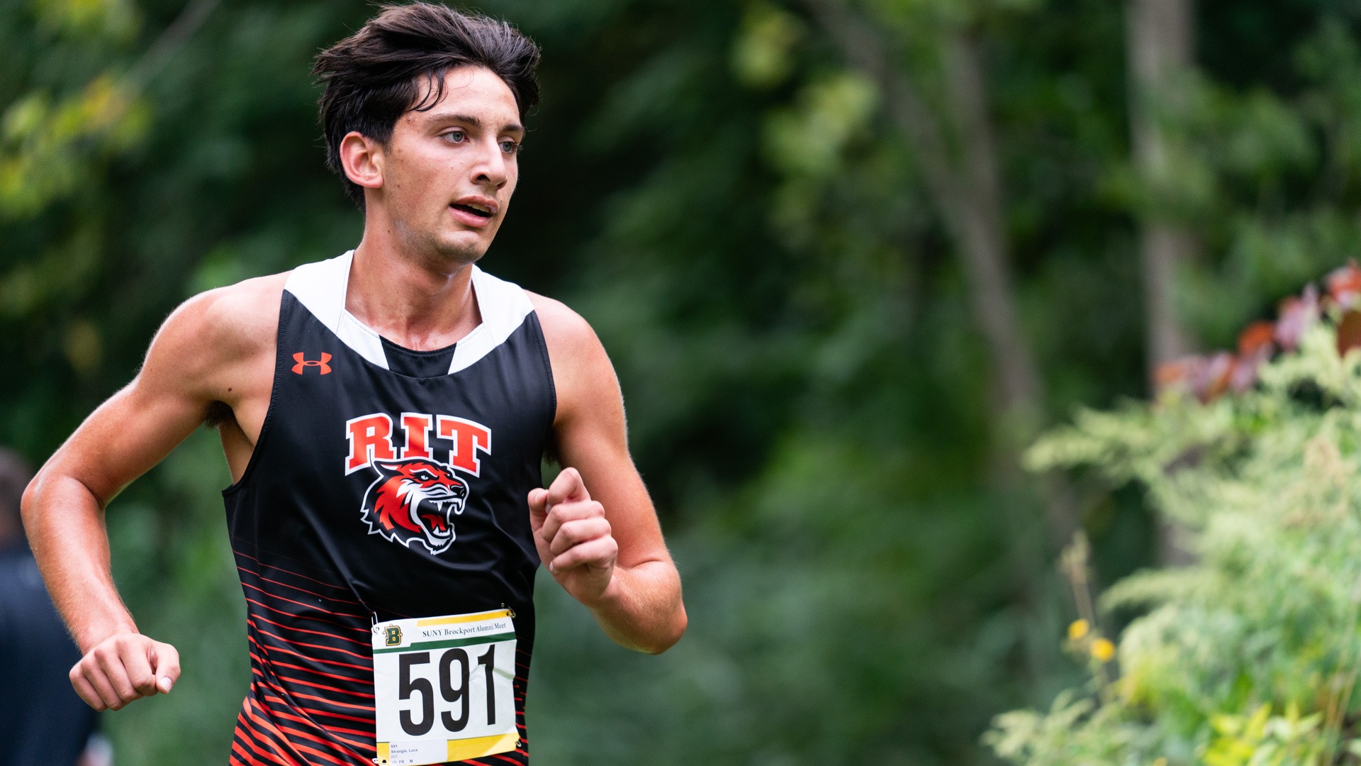 A men's cross country runner races in a meet for Rochester Institute of Technology