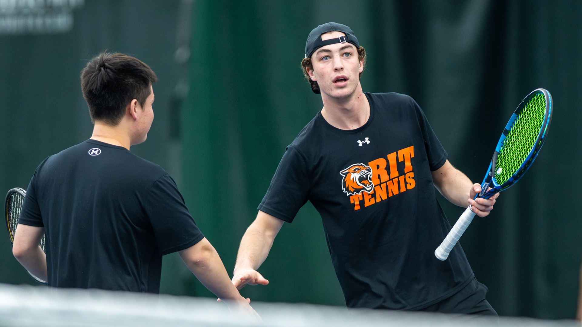 A photo of Yu Tanimoto and Alexander Sinclair congratulating each other after winning a point