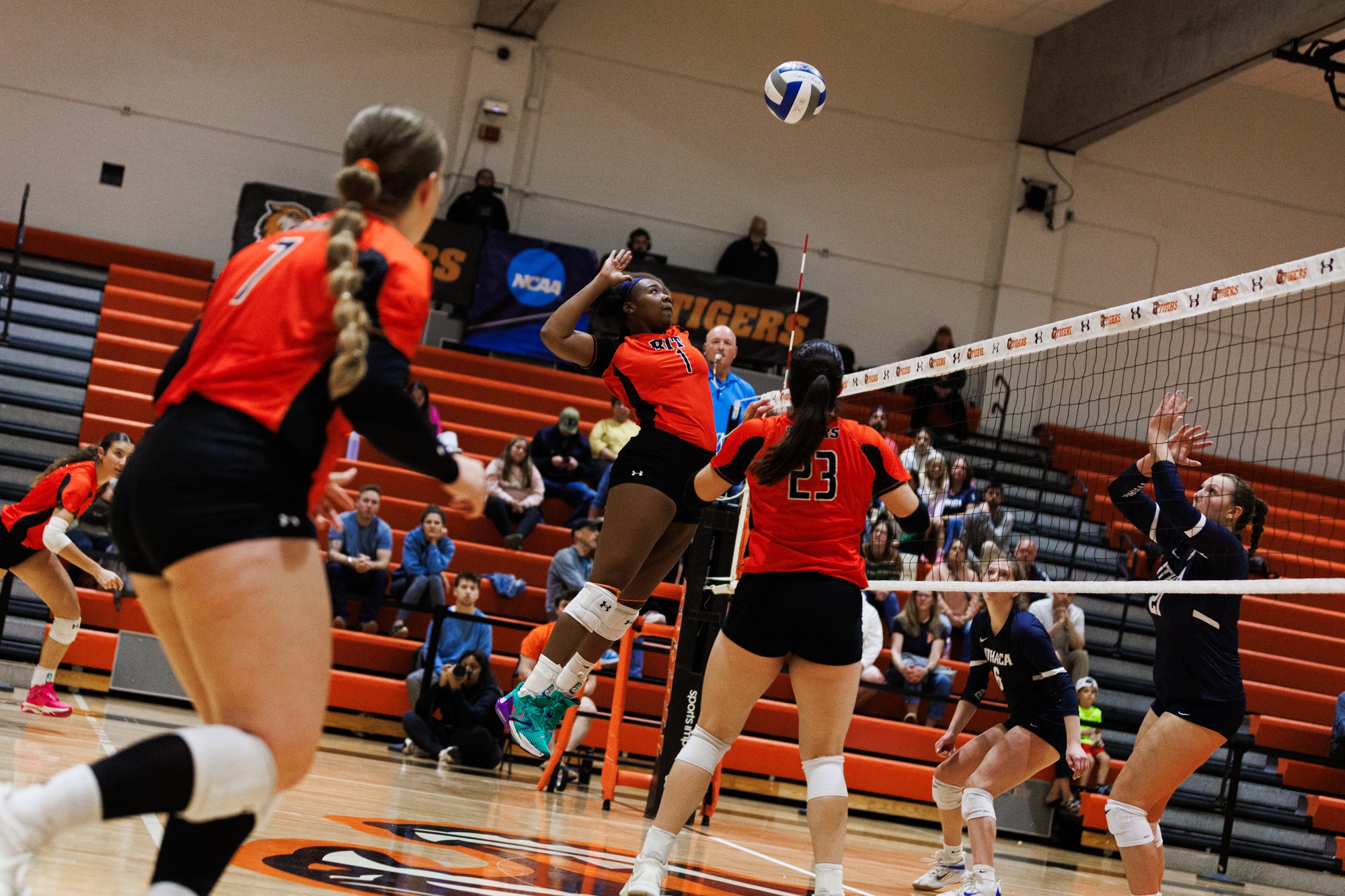 a women's volleyball attacking at the net