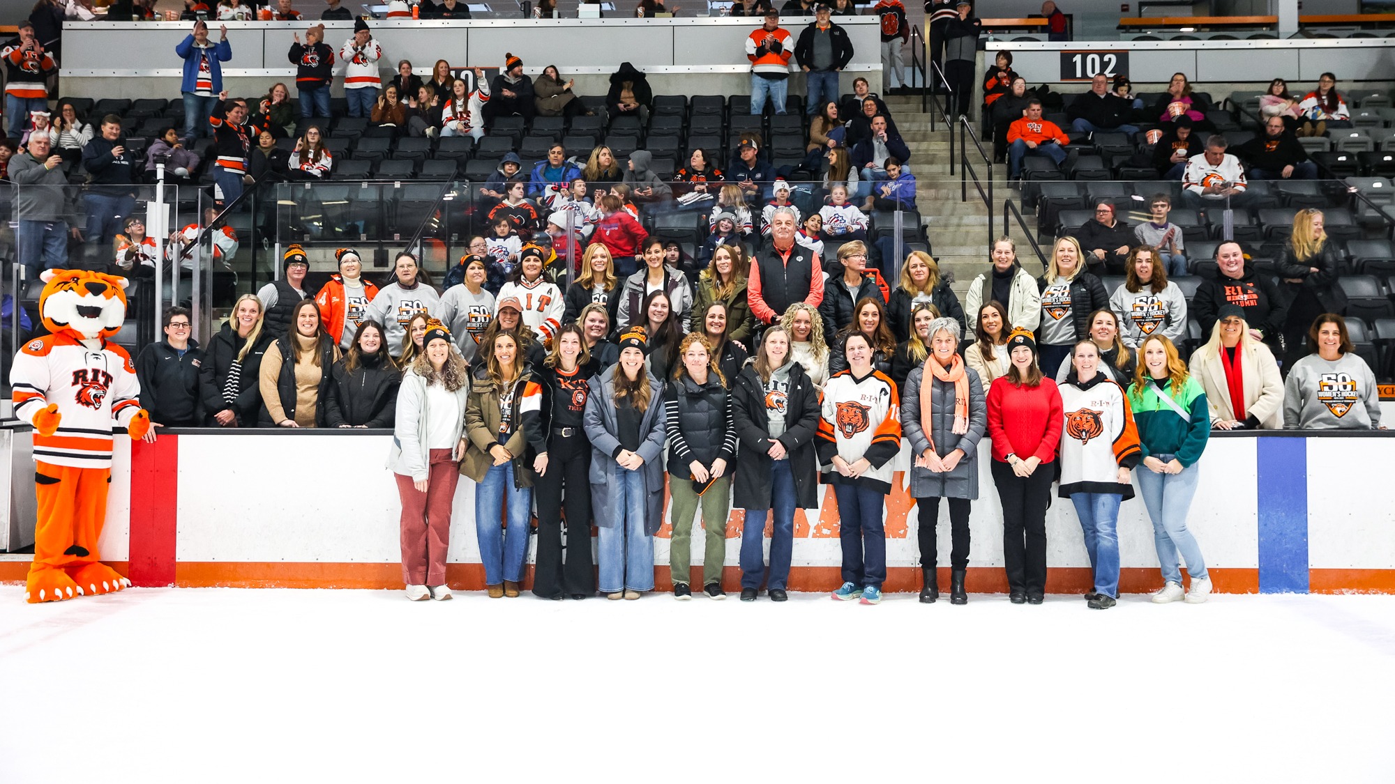 RIT Women's Hockey Alumni pose for a photo on 50th anniversary of Women's Hockey in game vs Delaware University on Saturday, Dec. 6, 2025, at Gene Polisseni Center. RIT Women's Hockey game vs. Delaware University. (Mikaela Engstrom/RIT Sports Network).