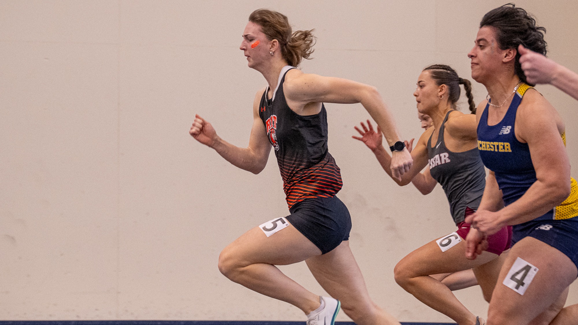 A women's sprinter for Rochester Institute of Technology leads the field in a race