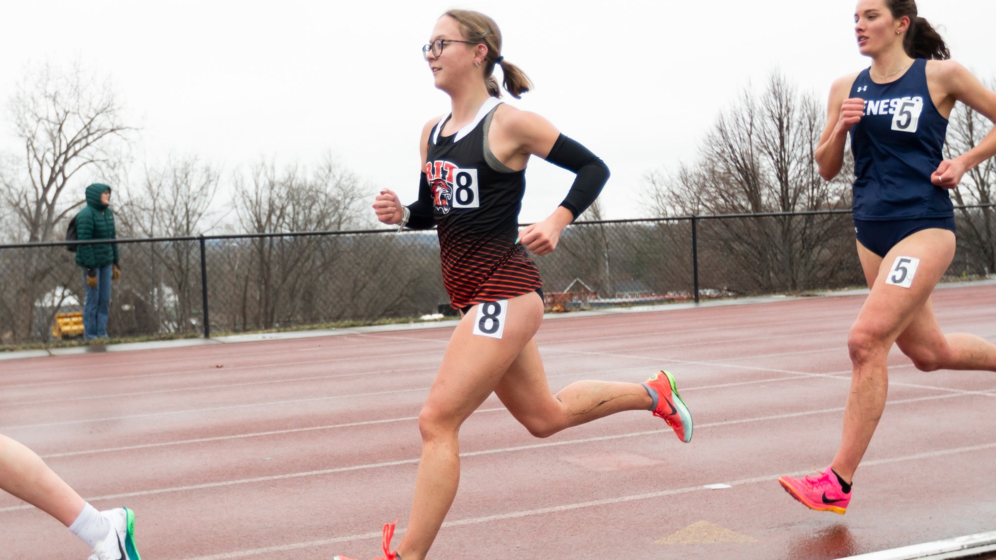 A women's track and field distance runner competes in a race for Rochester Institute of Technology 