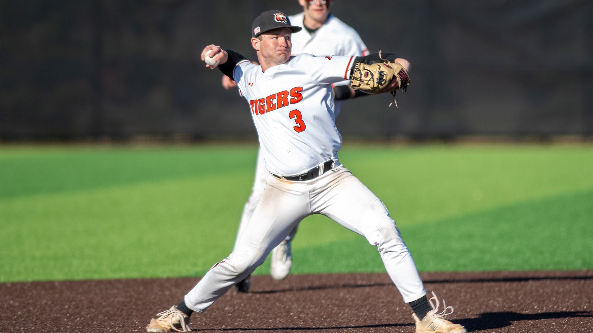 Rochester Institute of Technology's third baseman make a throw to first base