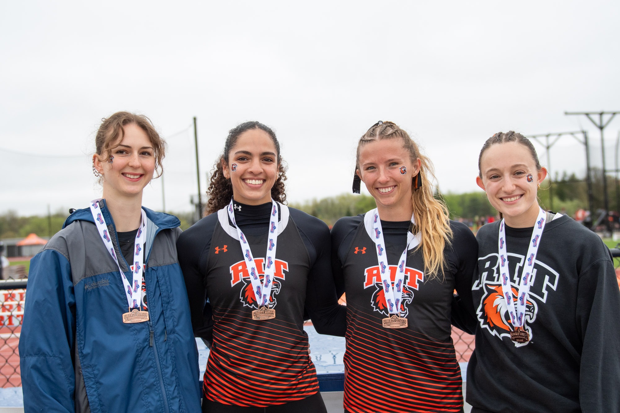 runners from Rochester Institute of Technology celebrate winning medals at the 2025 Liberty League Outdoor Track and Field Championships