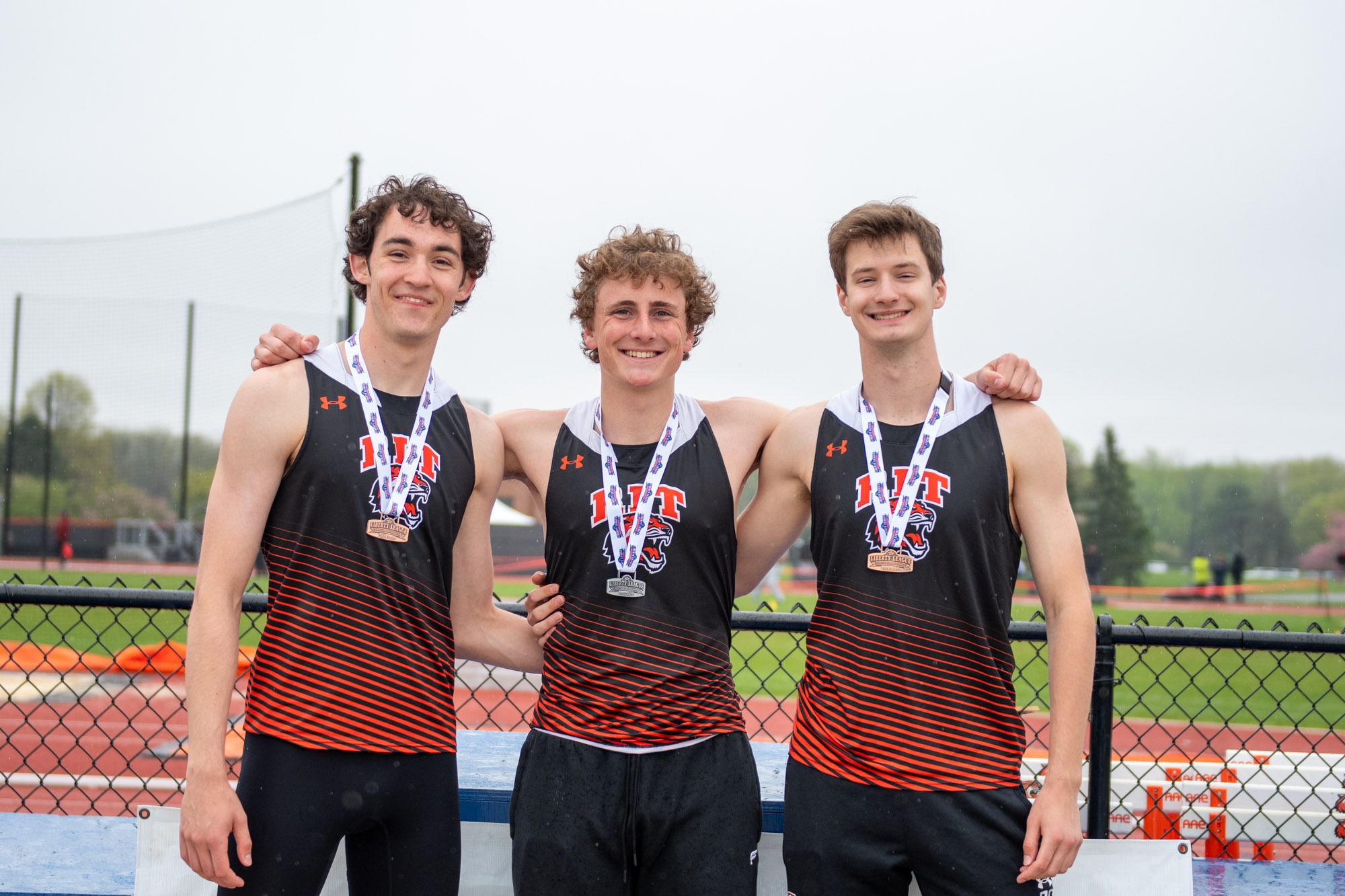 Three Rochester Institute of Technology high jumpers wearing their medals at the 2025 Liberty League Championships