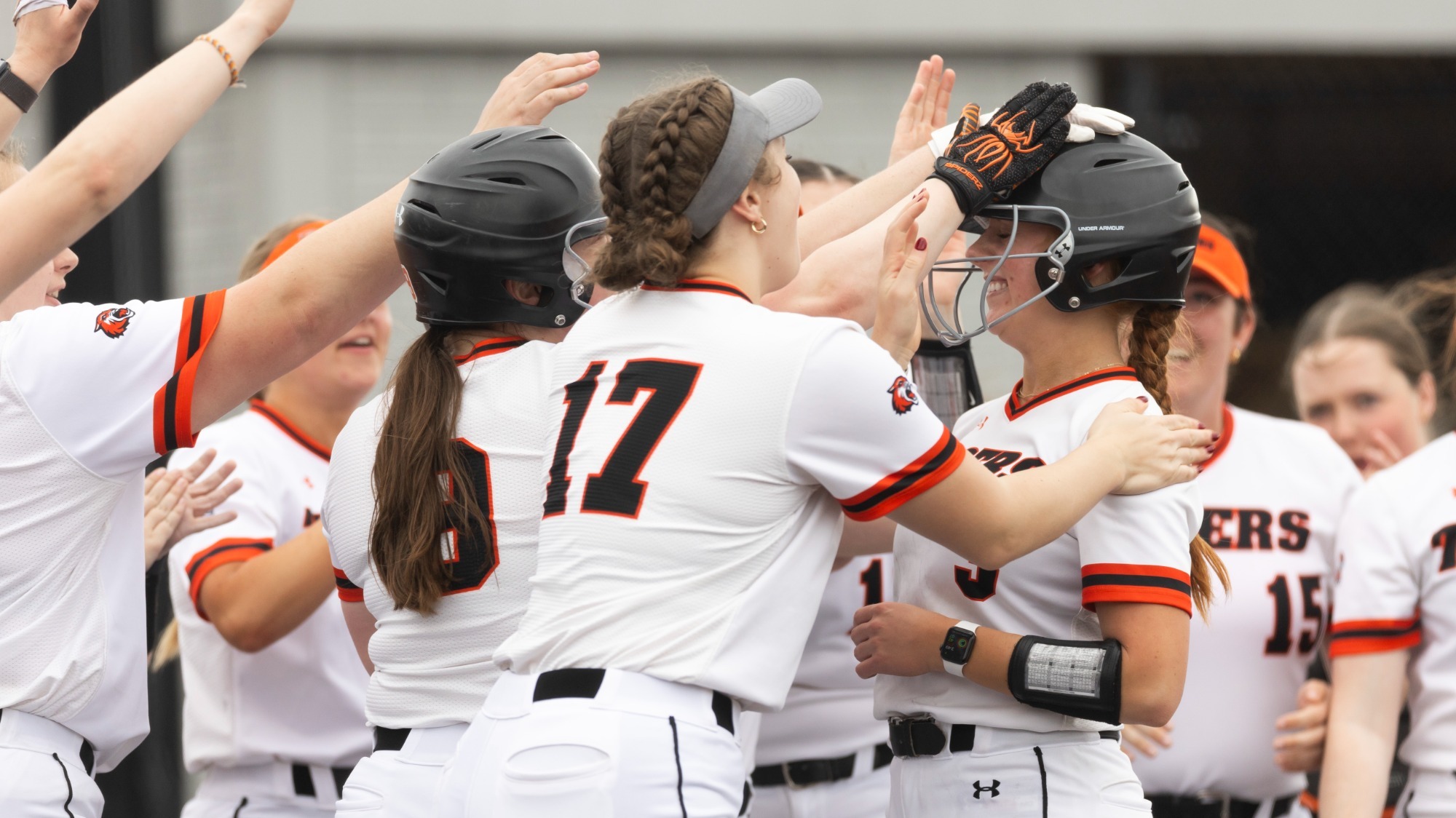 softball players celebrating a teammate.