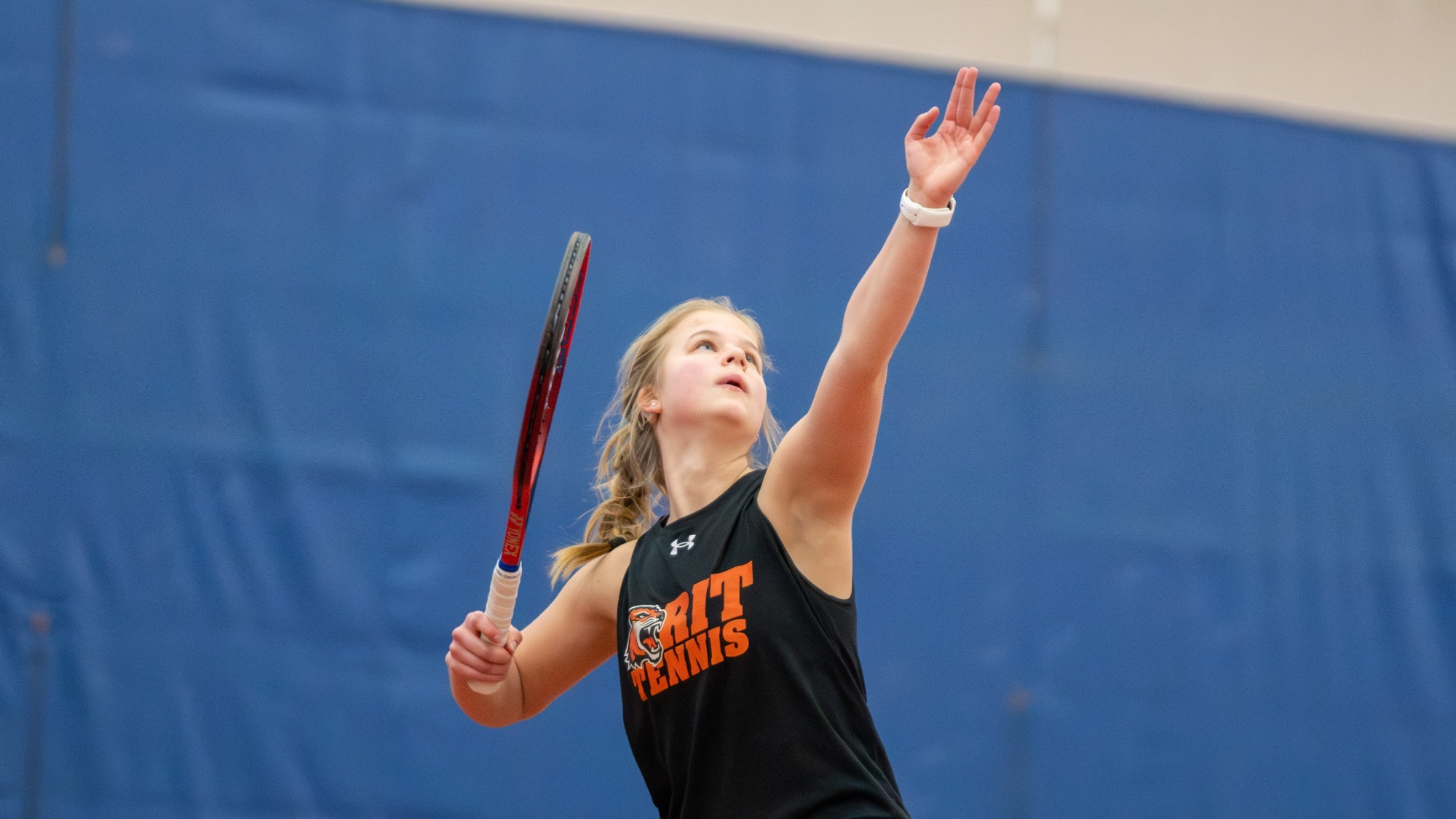 Emily Greb hitting a serve during a match