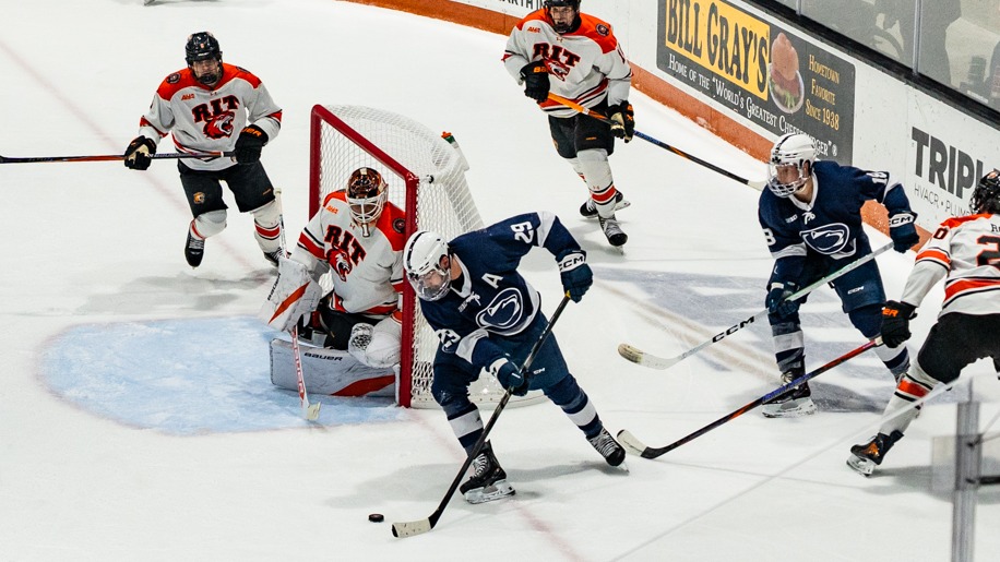 men's hockey players battling in front of the goal