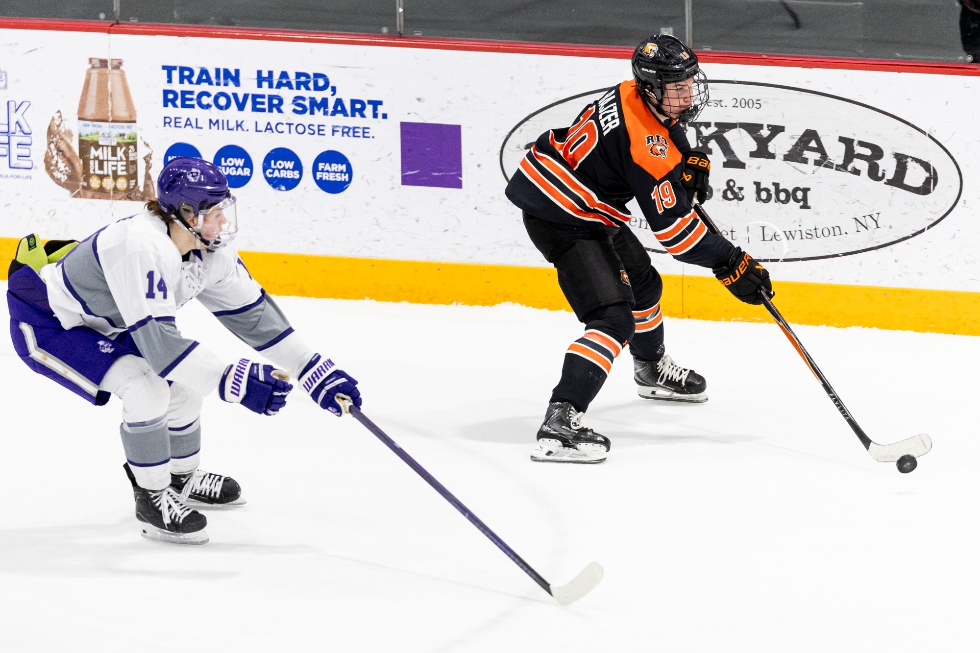 a men's hockey player skating with the puck