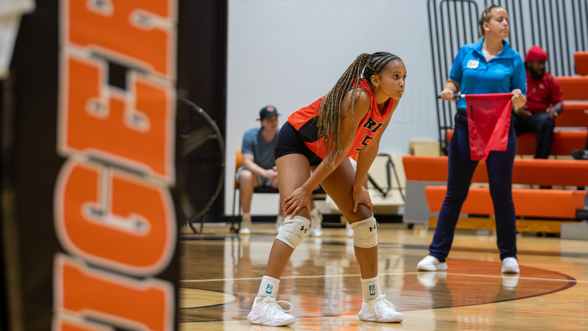 a women's volleyball player waiting for a serve