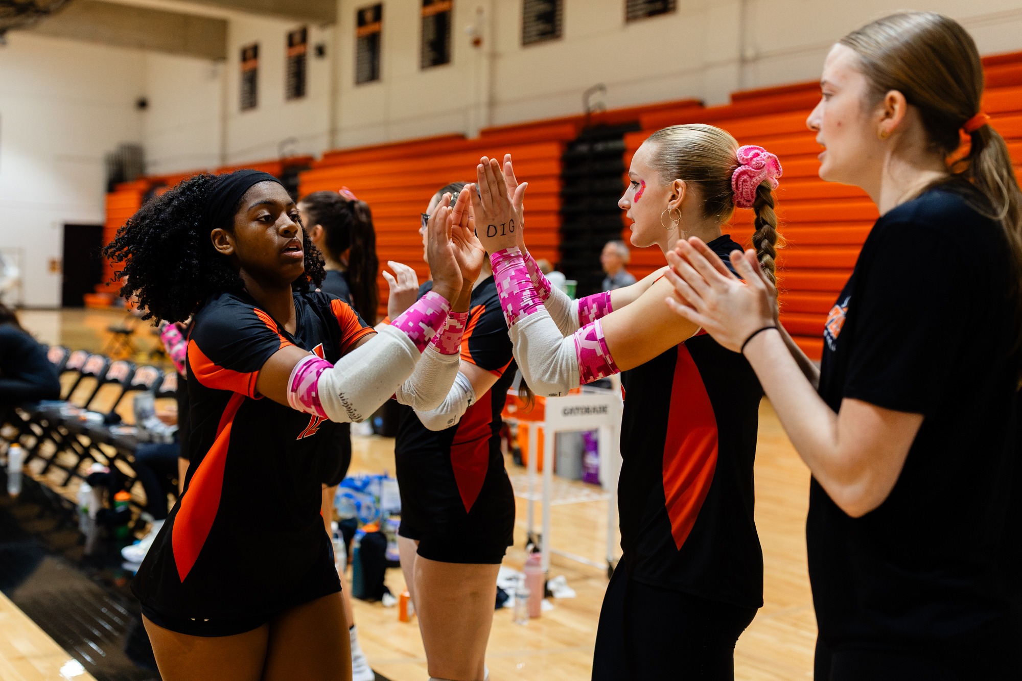 Women's Volleyball players high fiving before a match