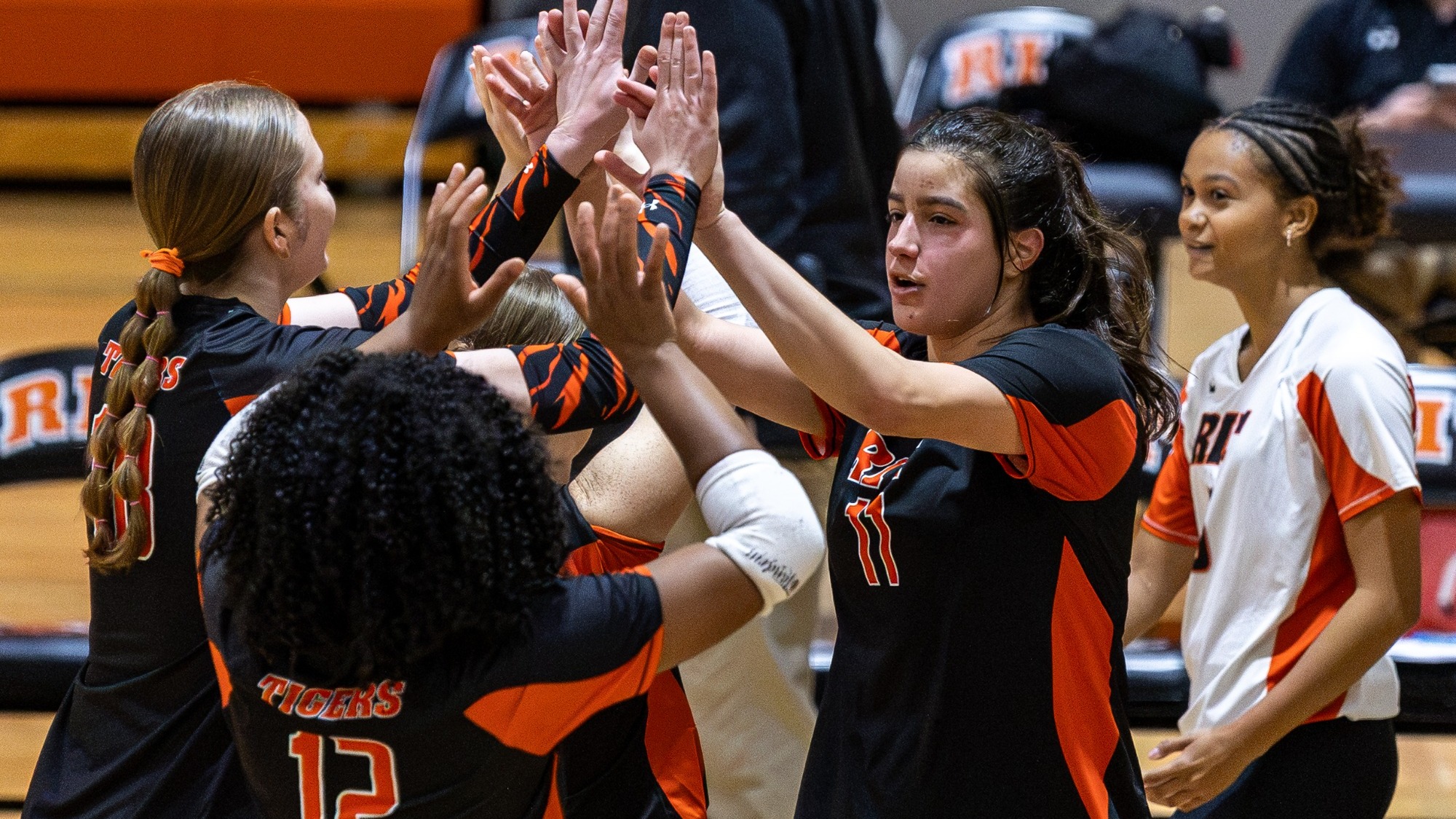 a women's volleyball player high fiving a teammate