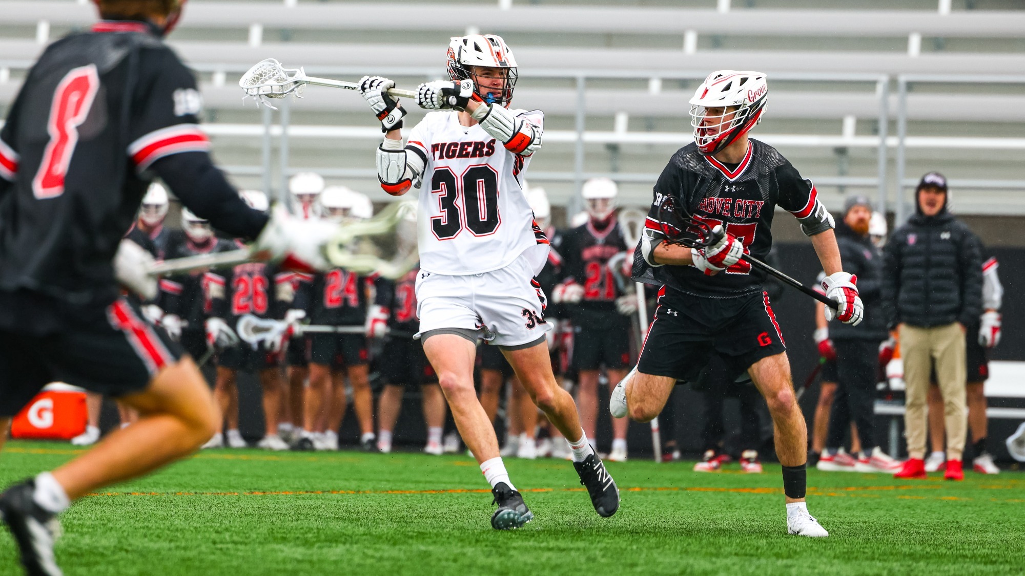 a men's lacrosse player looking to pass in front of a defender