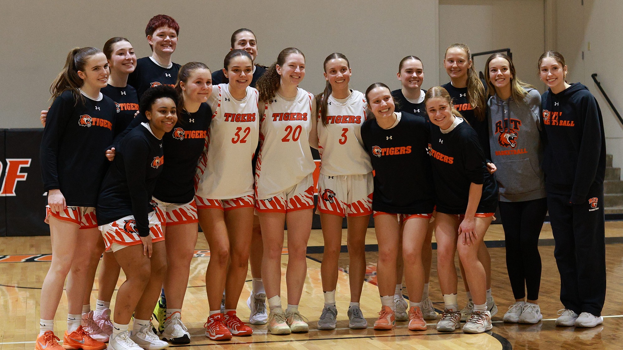 the RIT women's basketball team poses with the three departing seniors before a game on Feb. 21, 2026.