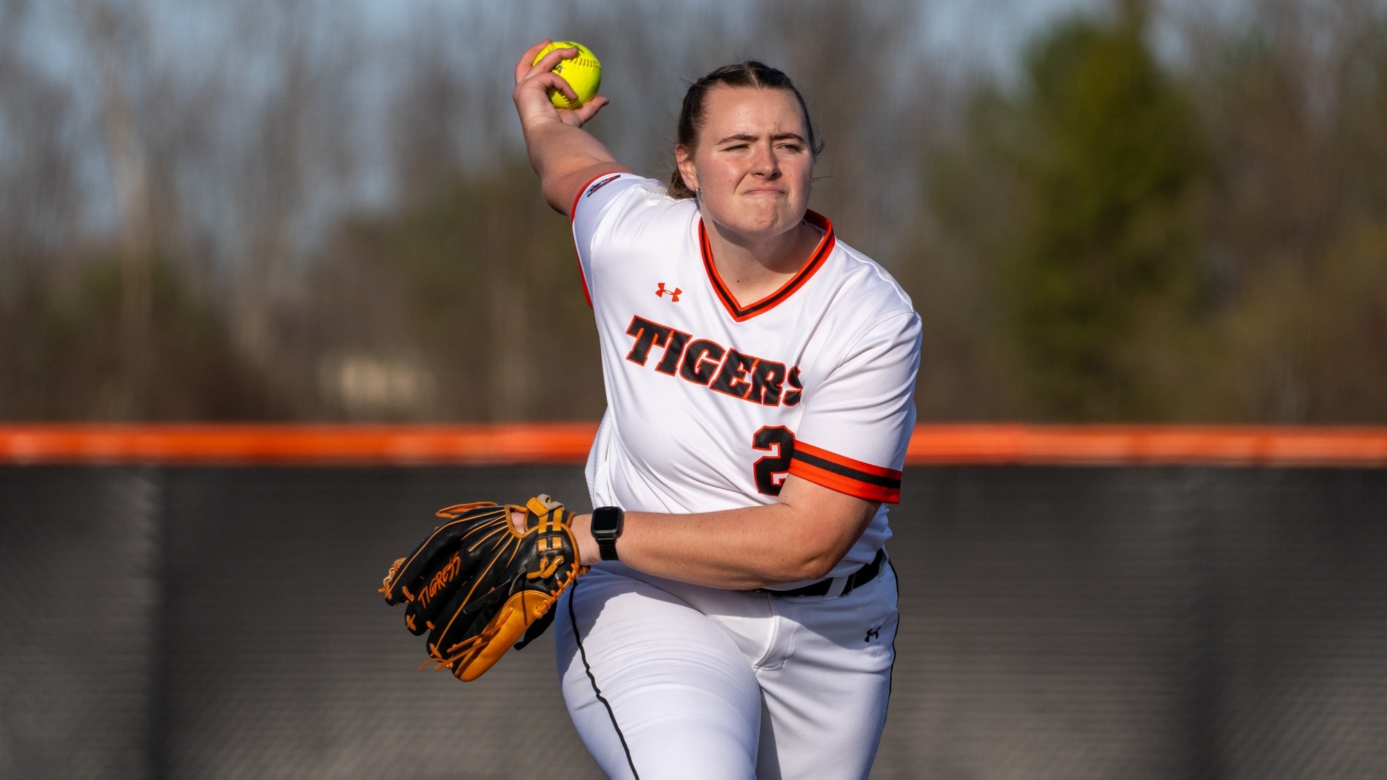 a softball pitcher in the middle of her windup