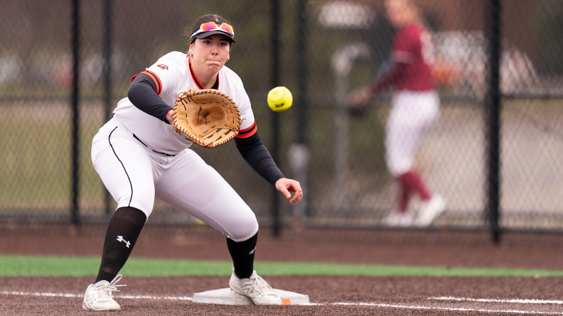 a first baseman about to catch a throw to first