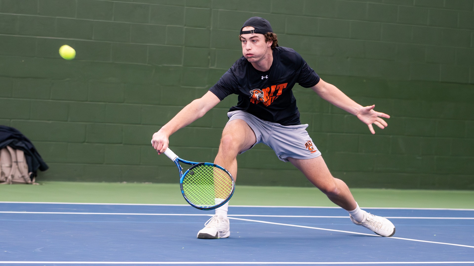 A RIT tennis player returns a ball using his forehand