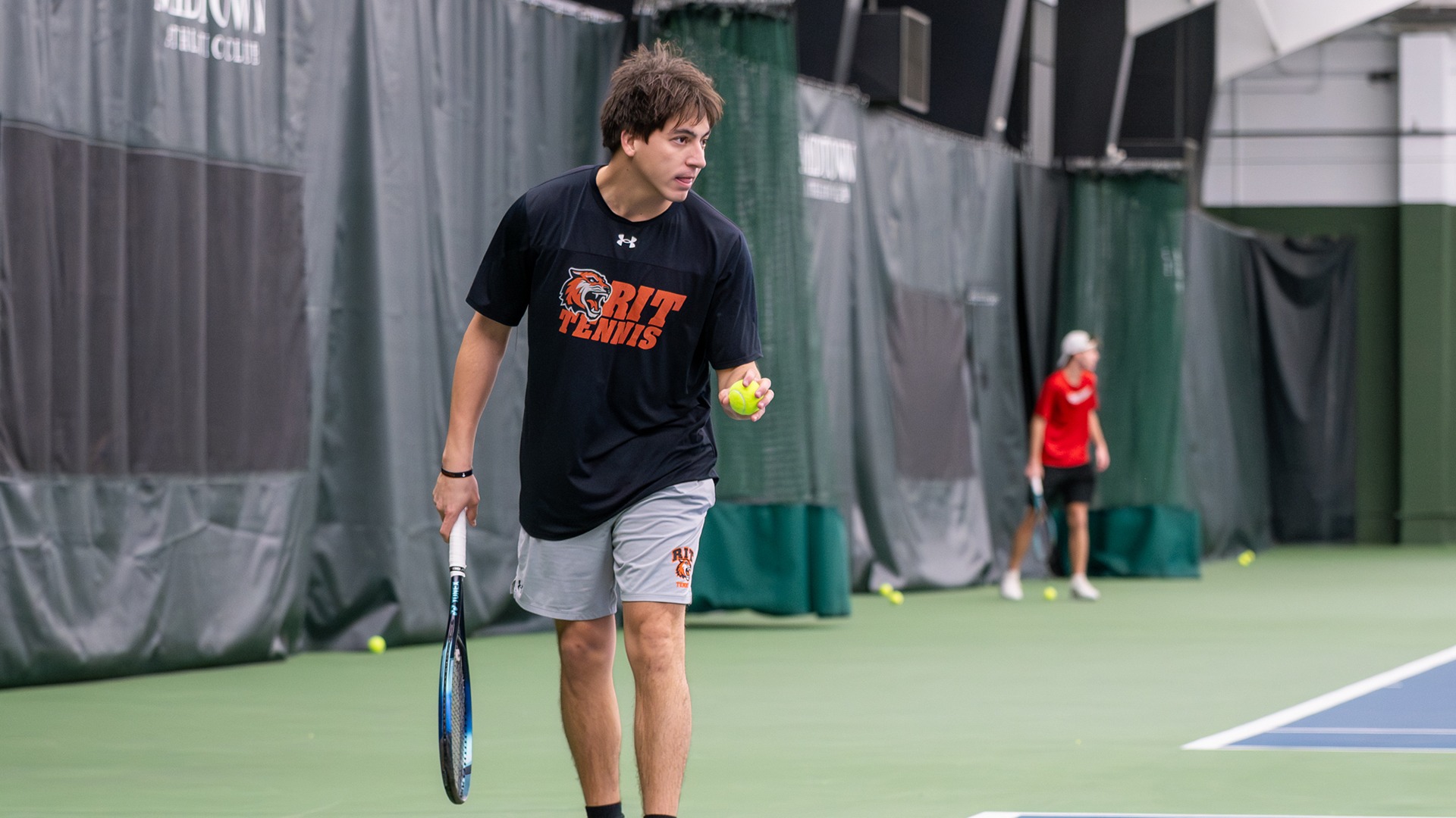 A men's tennis prepares to serve