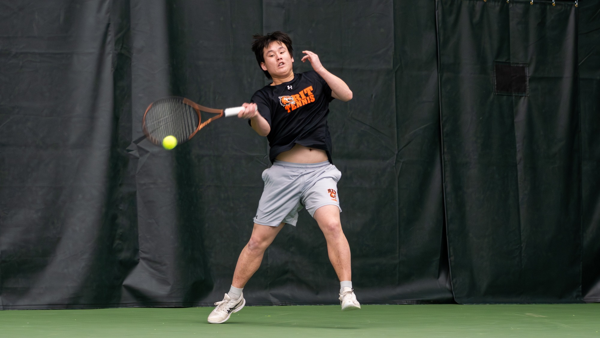 A men's tennis player hits a foreheand